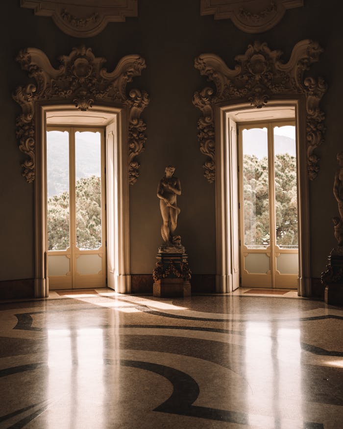 Sunlit elegant interior room in Stresa, Italy featuring classic architecture and statues.